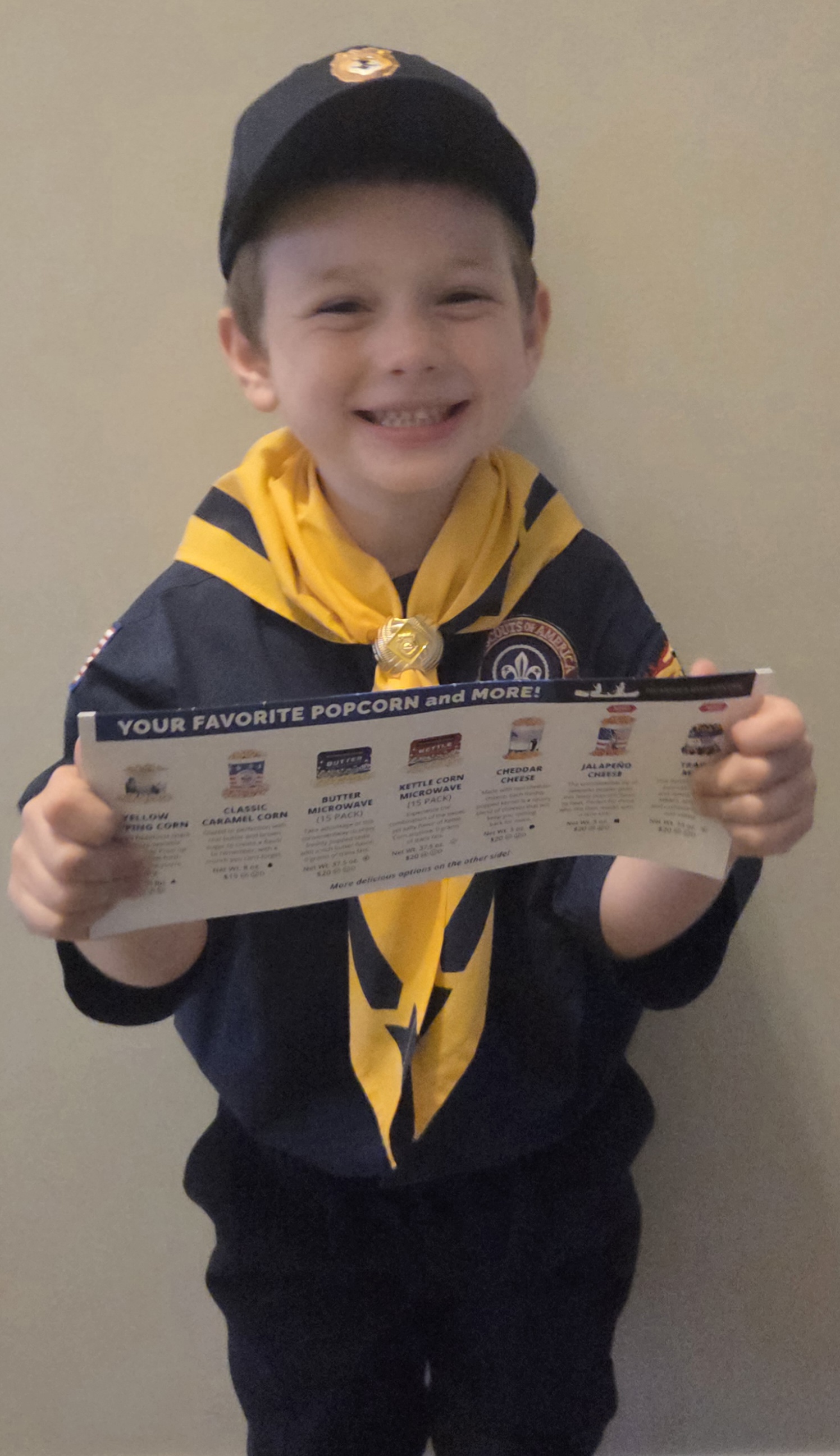 Jace in his Cub Scout uniform holding a popcorn flyer